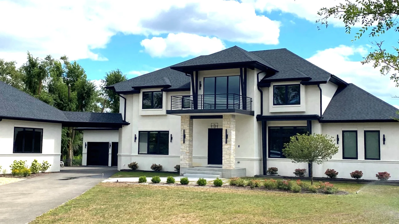 The front of a large home with white siding, multiple windows, and a black roof in LaGrange, IL by Apex Exteriors.