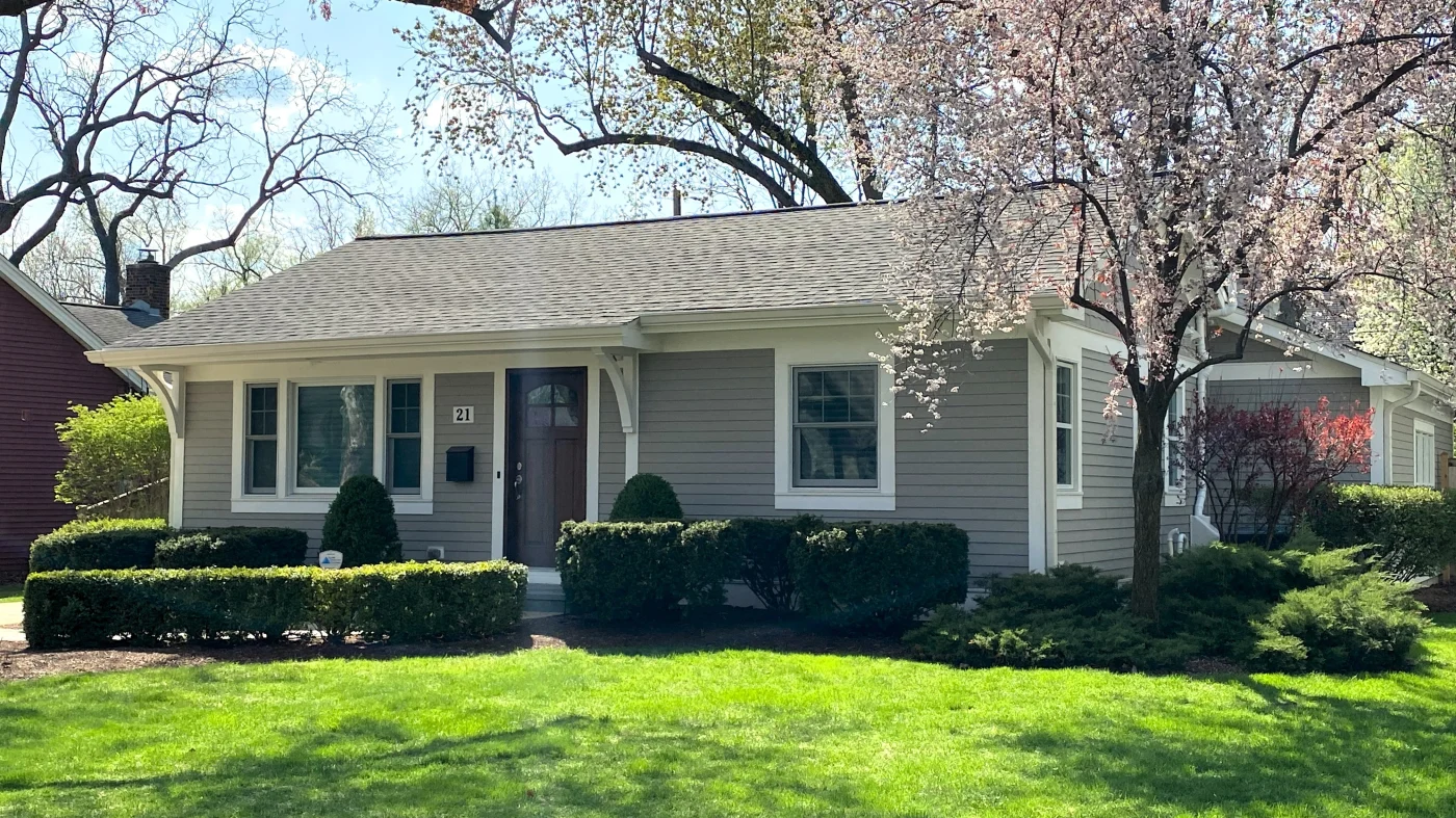 Exceptional Roofing Experts Elk Grove Village Il Apex Exteriors Inc The front of a house with gray siding and white trim in Elk Grove Village, IL, by Apex Exteriors, Inc.