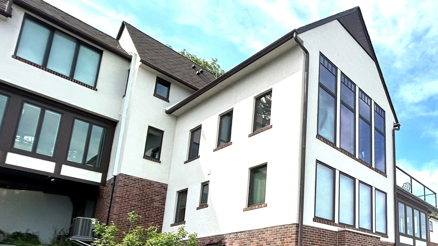 A large building with multiple windows and white siding in Bloomingdale, IL by Apex Exteriors.