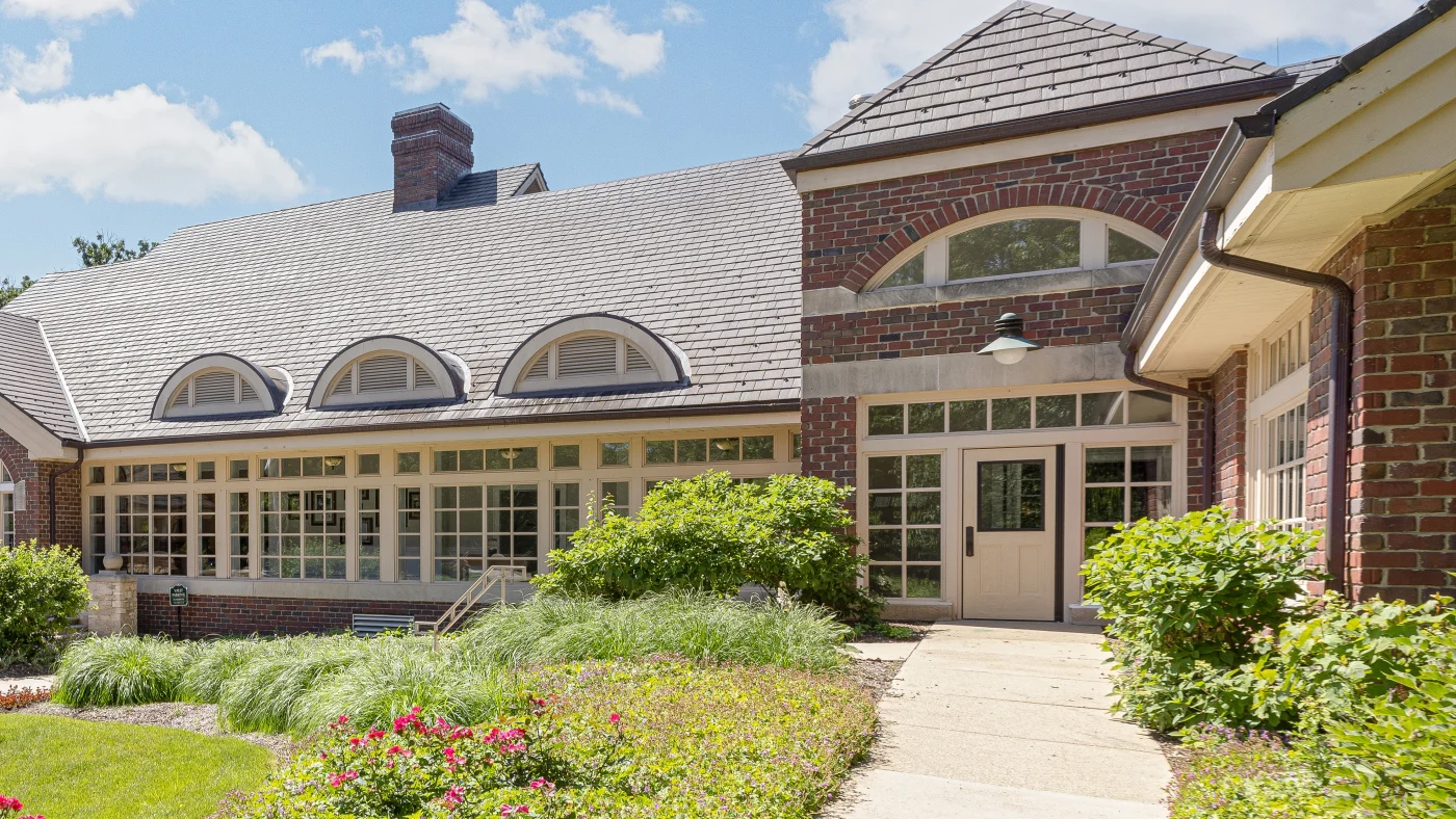 The front of a large building with a brown roof in Wheaton, IL by Apex Exteriors.