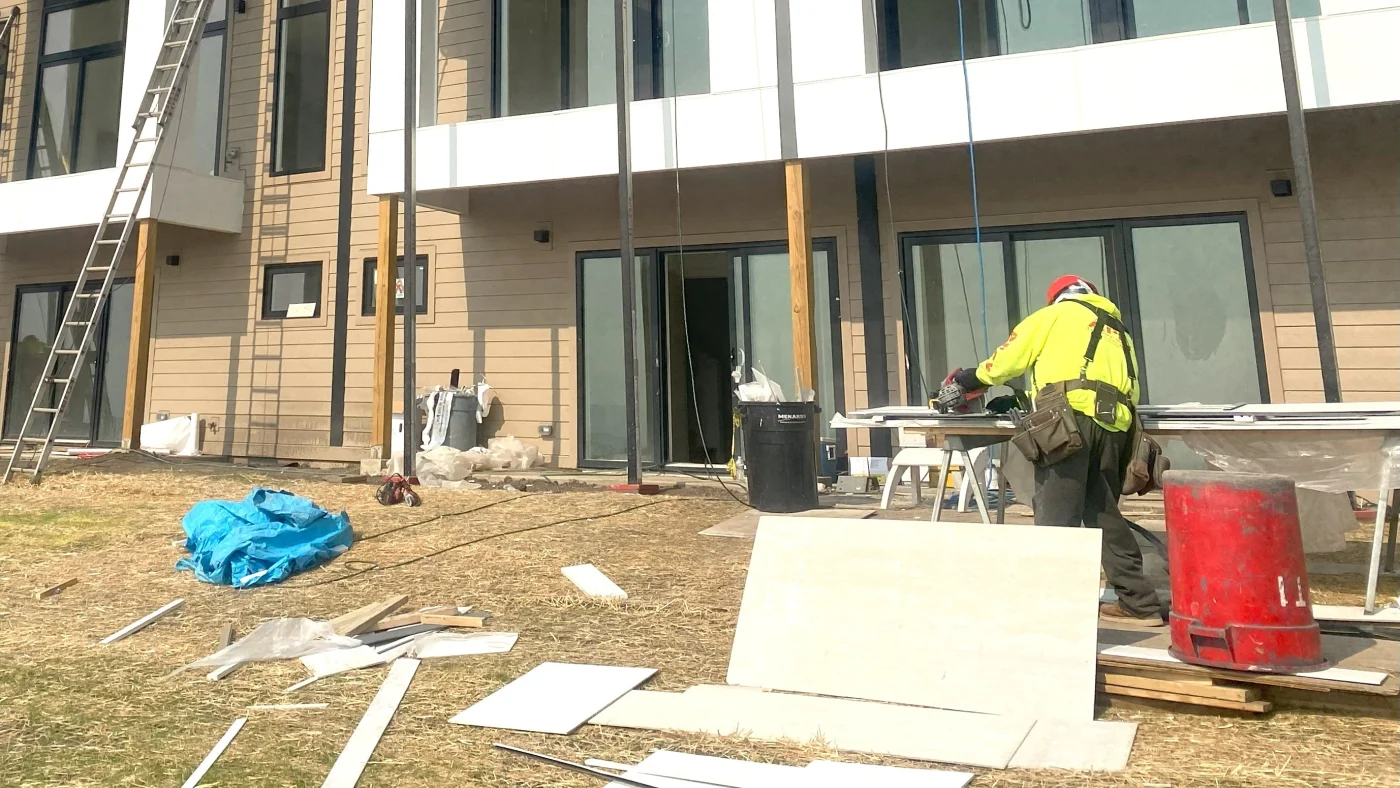 A crew member is working to install siding on a commercial building in LaGrange, IL by Apex Exteriors.