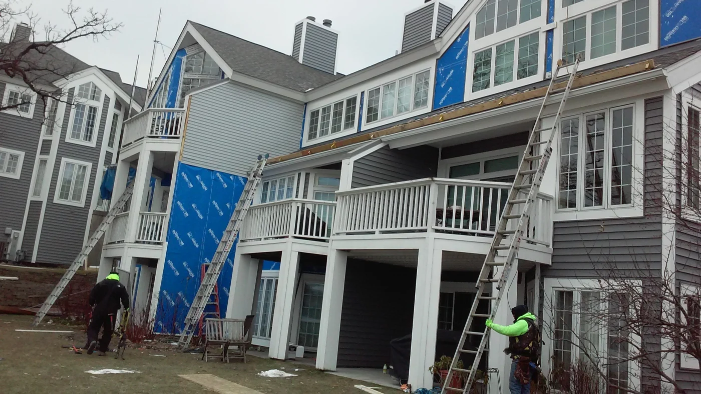 Crew members install new gray siding on a house in Bloomingdale, IL by Apex Exteriors.