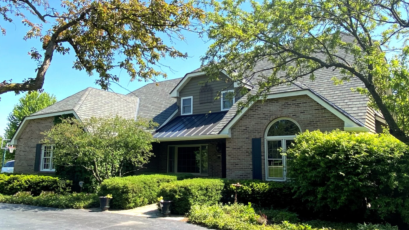 The front of a house with light brown brick siding and a light brown roof in Glenview, IL by Apex Exteriors.