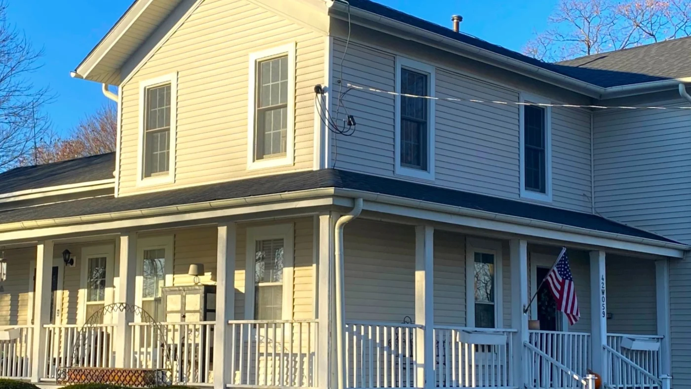 An angled view of a home with off-white siding and white trim in LaGrange, IL by Apex Exteriors.