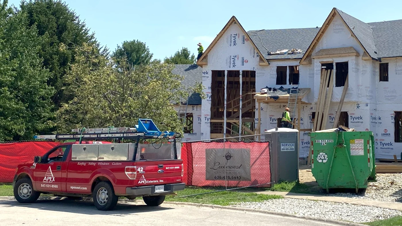 An Apex Exteriors truck parked in front of a home under construction in Wheaton, IL.
