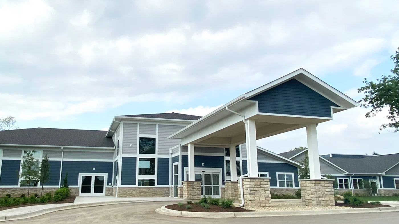 The front of a one-floor commercial building with wite and blue siding in Bloomingdale, IL by Apex Exteriors.