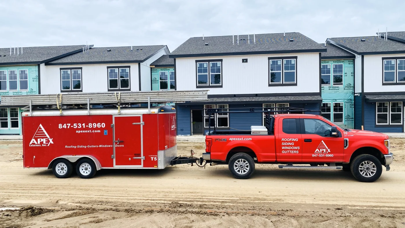 An Apex Exteriors truck in front of apartment buildings in Elmhurst, IL by Apex Exteriors.