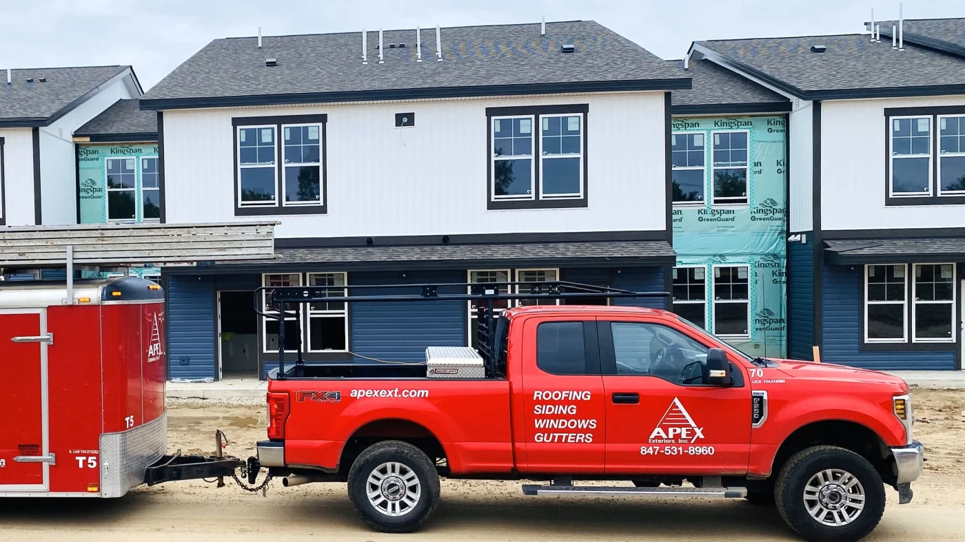 An Apex Exteriors truck parked in front of an apartment building in Lombard, IL.