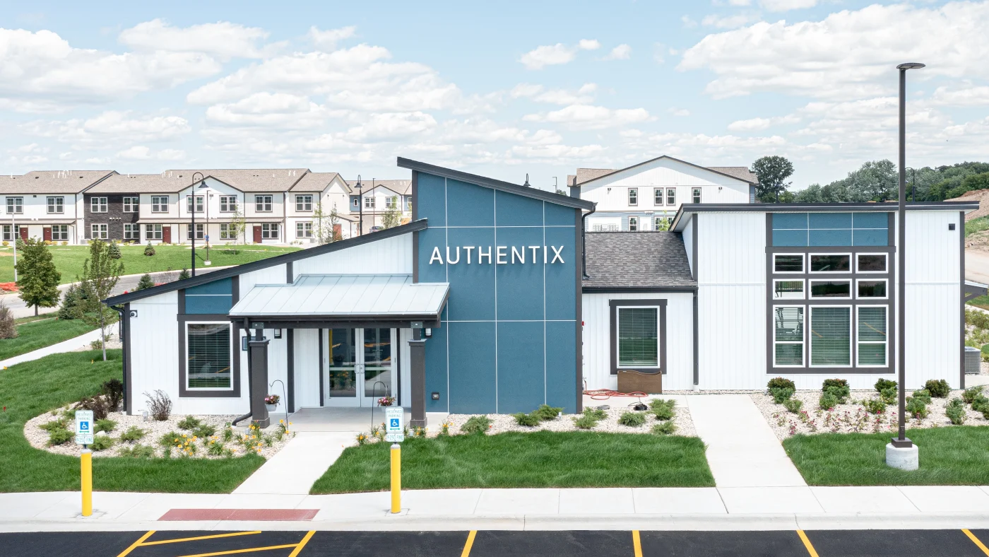 The front of a commercial building at an apartment complex with white siding in Glenview, IL by Apex Exteriors.