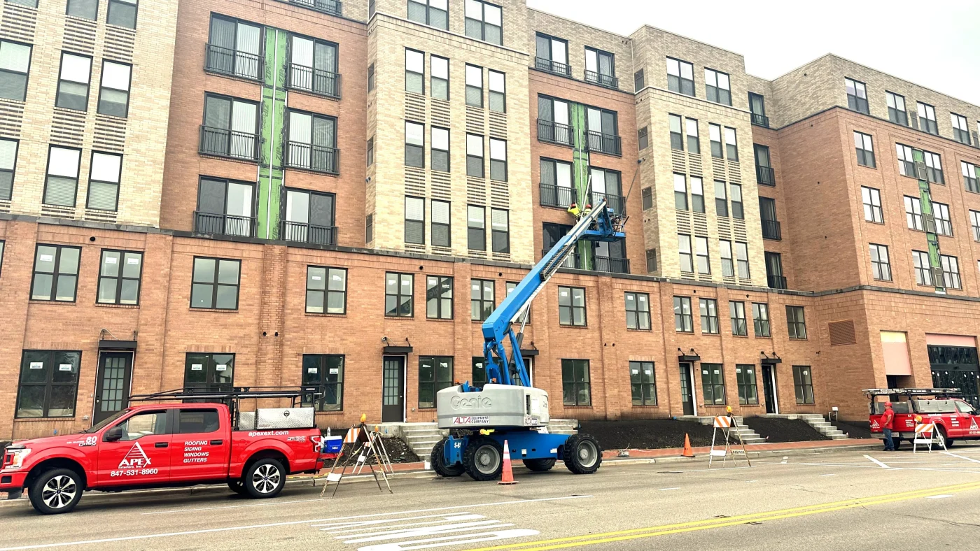 A street view of a multi-story building having some of its siding replaced in Bloomingdale, IL by Apex Exteriors.