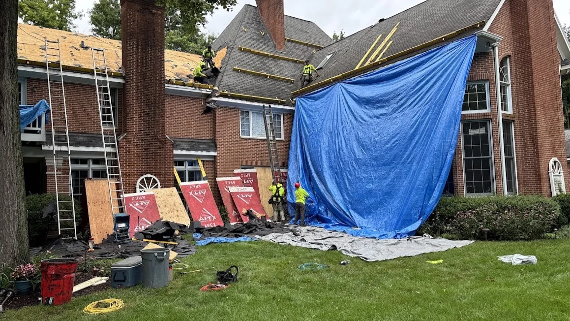 A roofing crew is installing a new roof on a house in LaGrange, IL, by Apex Exteriors.