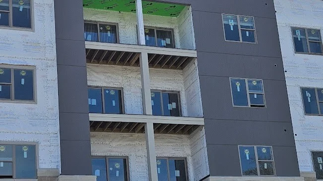 Looking up at a commercial building with brown and beige siding in Bloomingdale, IL by Apex Exteriors.