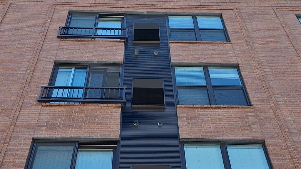 Looking up at a red brick commercial building in Glenview, IL by Apex Exteriors.