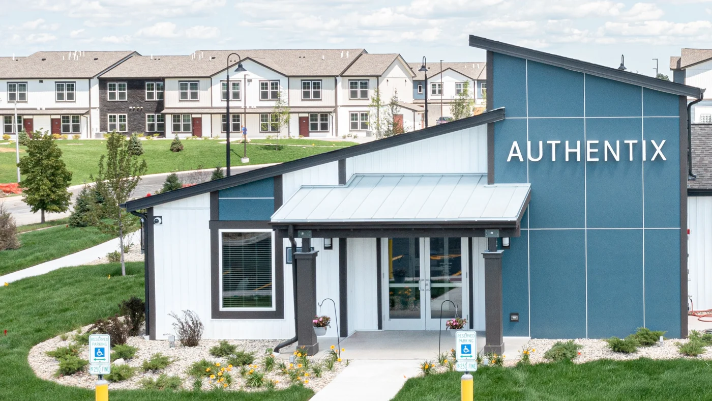 The front of a building in part of an apartment complex with white siding in Bloomingdale, IL by Apex Exteriors.