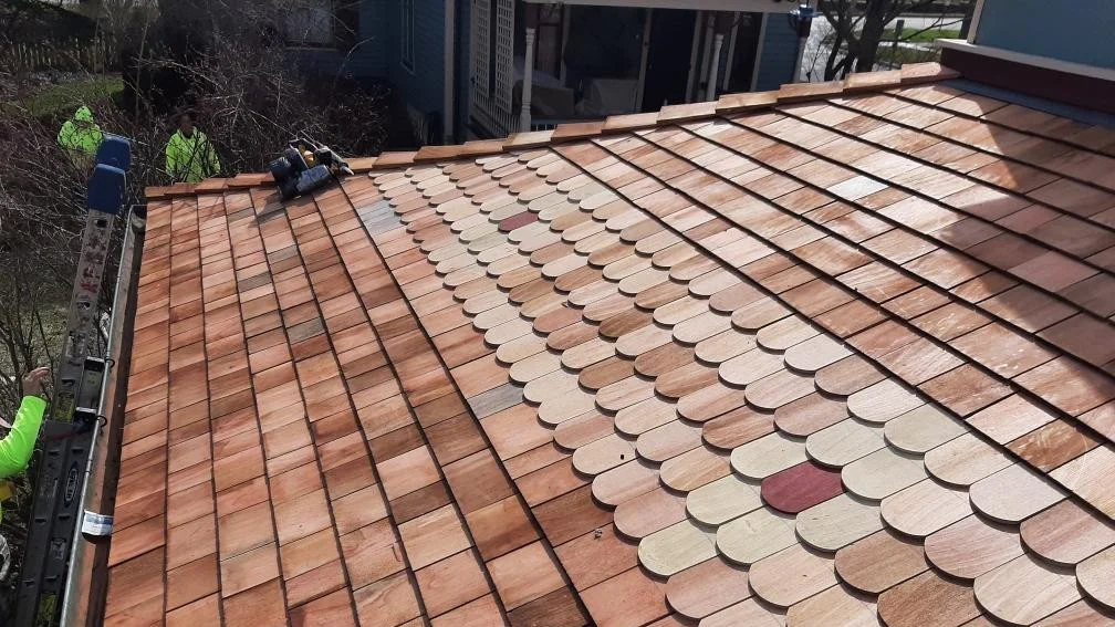 Roofers installing a light brown roof in Glenview, IL, by Apex Exteriors, Inc.