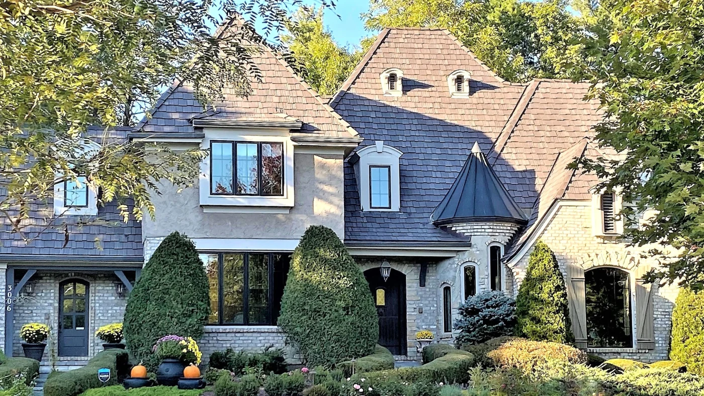 The front of a house with beige siding and a brown roof in Lombard, IL, by Apex Exteriors.