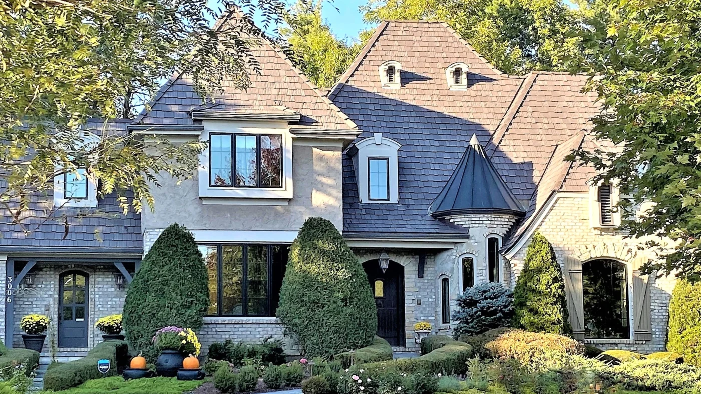 The front of a house with beige siding and a brown roof in Wheaton, IL, by Apex Exteriors, Inc.