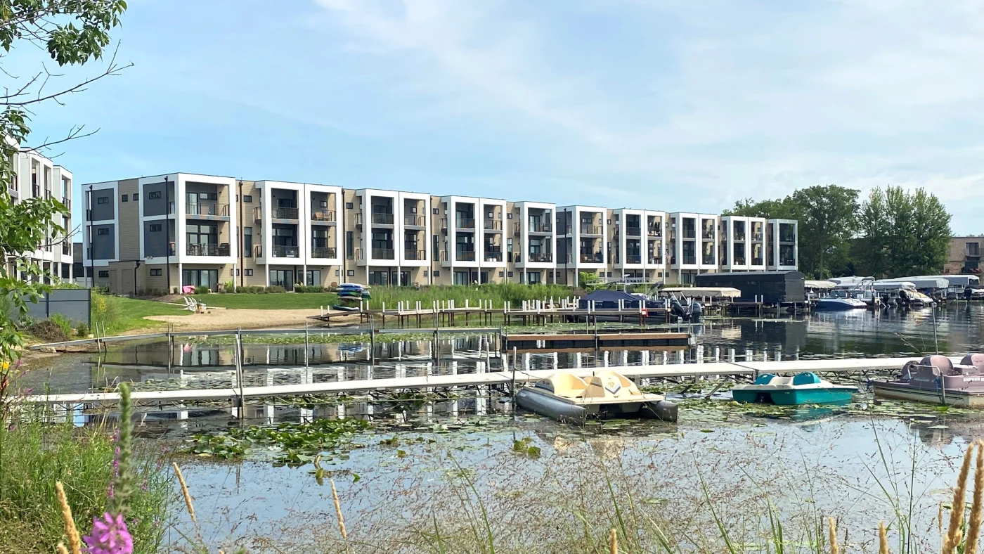 A view across a lake at a multi-family housing building in Elk Grove Village, IL, by Apex Exteriors, Inc.