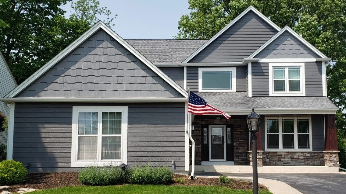 Excellent Residential Siding Replacement | Plainfield, IL | Apex Exteriors, Inc. The front of a house with gray siding and white trim in Plainfield, IL, by Apex Exteriors, Inc.