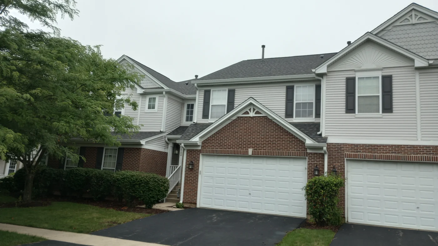 Excellent Roofing Services | Crystal Lake, IL | Apex Exteriors, Inc. The front of connected houses with two types of siding and gray roofs in Crystal Lake, IL, by Apex Exteriors, Inc.