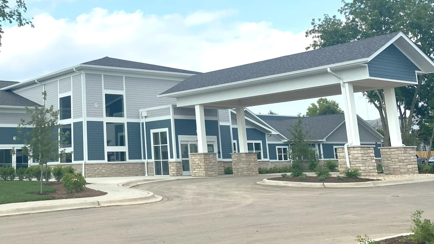 The front of a commercial building with blue and gray siding with white trim in Elk Grove Village, IL, by Apex Exteriors, Inc.