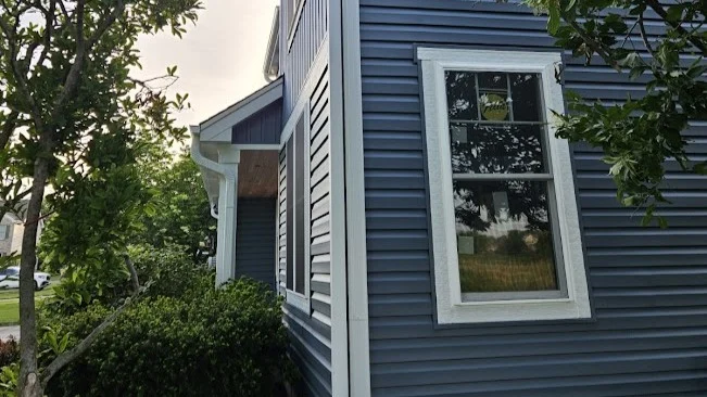 Exceptional Window Replacement | Northbrook, IL | Apex Exteriors, Inc. The side of a house with blue siding and white trim in Northbrook, IL, by Apex Exteriors, Inc.