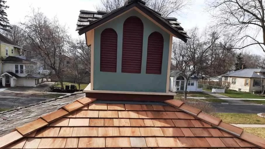 The close-up of the top of a house with a brown roof in Lombard, IL, by Apex Exteriors.