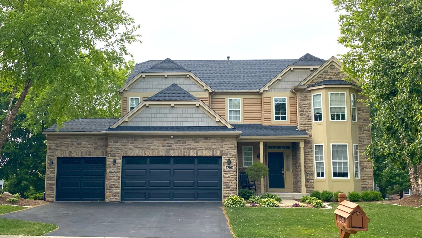 The front of a large house with brick and vinyl siding in Deerfield, IL, by Apex Exteriors, Inc.