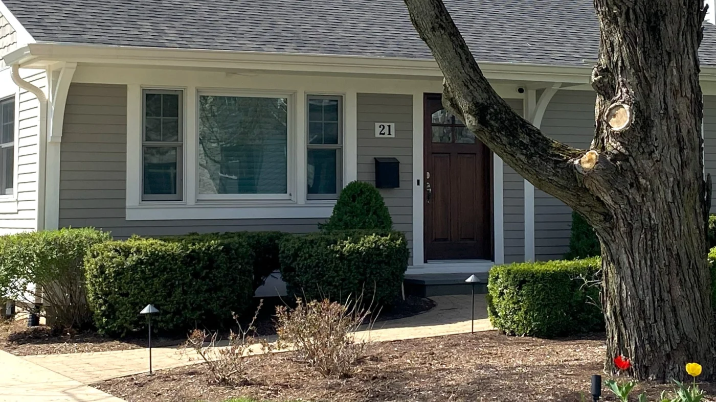 Exceptional Storm Windows | Buffalo Grove, IL | Apex Exteriors, Inc. The front of a house with a beautiful beige siding and a window trimmed in white in Buffalo Grove, IL, by Apex Exteriors, Inc.