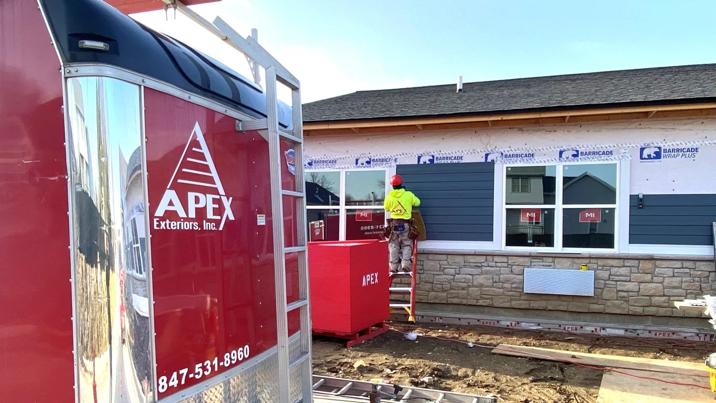 Expert Commercial Siding Pros | Plainfield, IL | Apex Exteriors, Inc. A crew member installing siding on a building in Plainfield, IL, by Apex Exteriors, Inc.