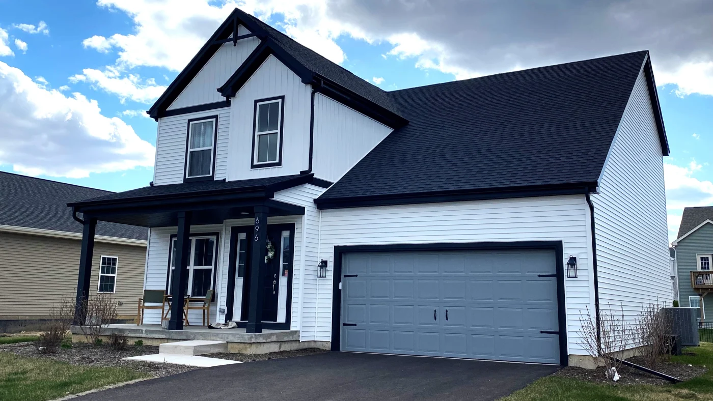 Expert New Home Construction | Plainfield, IL | Apex Exteriors, Inc. The front of a house with white siding and a black roof in Plainfield, IL, by Apex Exteriors, Inc.