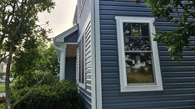Gorgeous Window Replacement | Plainfield, IL | Apex Exteriors, Inc. The side of a house with blue siding and white trim in Plainfield, IL, by Apex Exteriors, Inc.