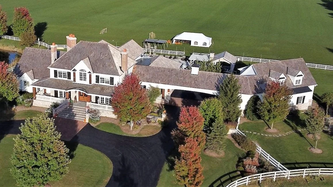 A sky view of a very large house with white siding and a brown roof, and some of the surrounding land in Plainfield, IL, by Apex Exteriors, Inc.