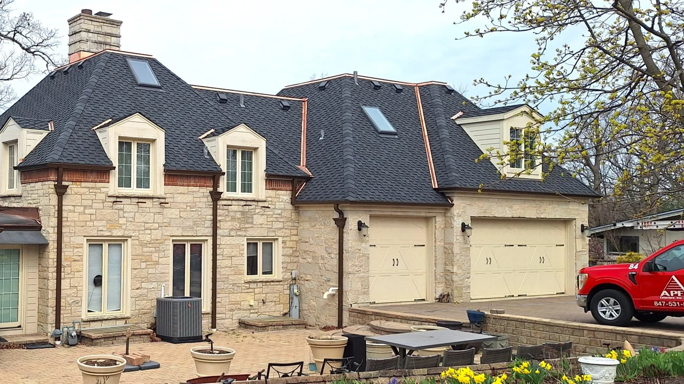 Outstanding Roof Replacement Pros | Bloomingdale, IL | Apex Exteriors, Inc. A house with beige siding and a dark gray roof in Bloomingdale, IL, by Apex Exteriors, Inc.