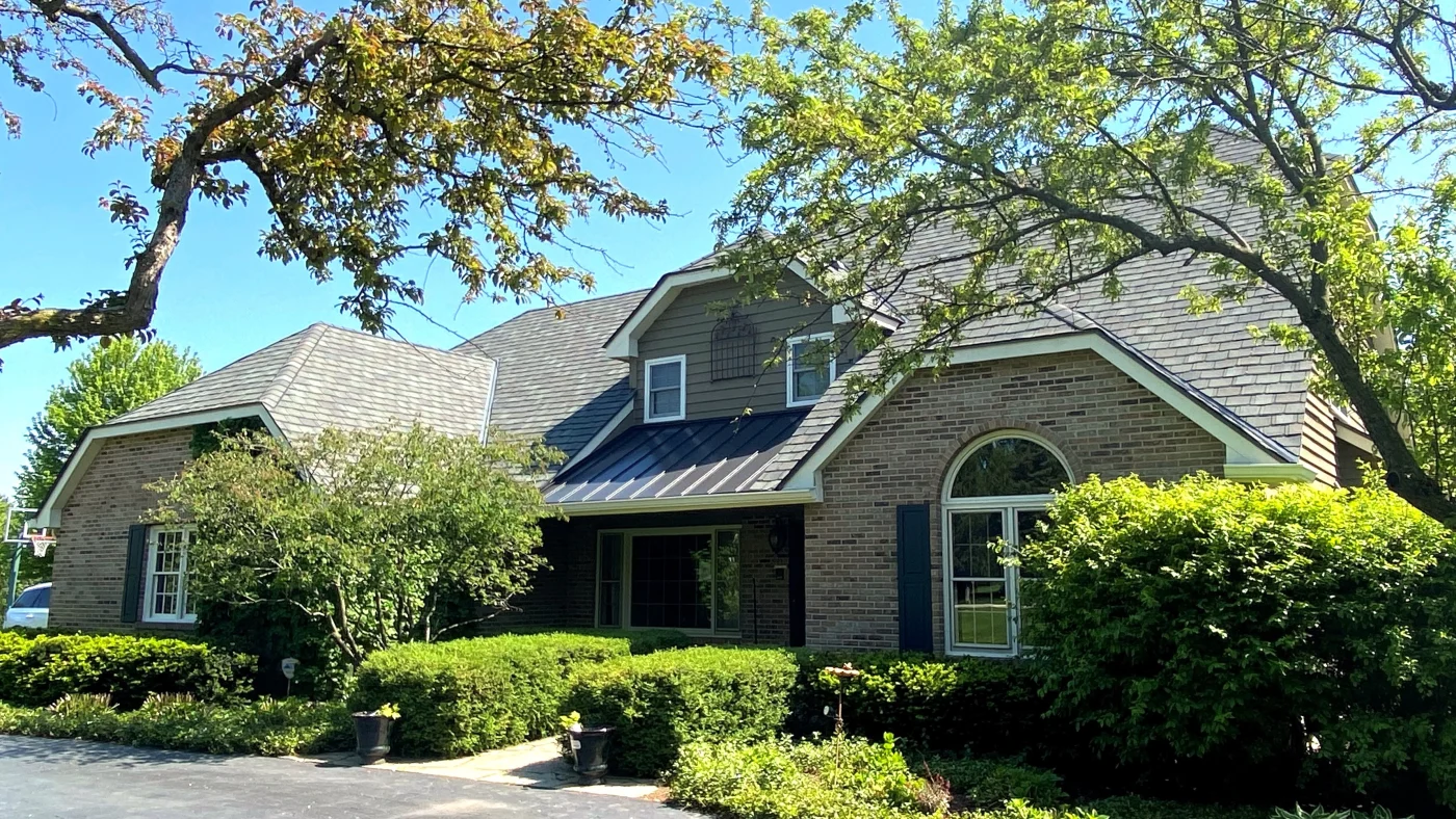 The front of a house with light brown siding and a light brown roof in LaGrange, IL, by Apex Exteriors, Inc.