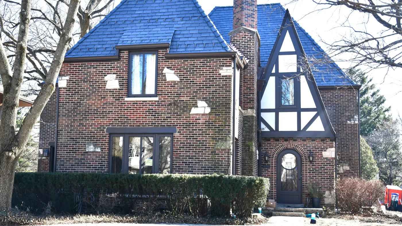 The side of a house with brown brick siding in Lombard, IL, by Apex Exteriors.