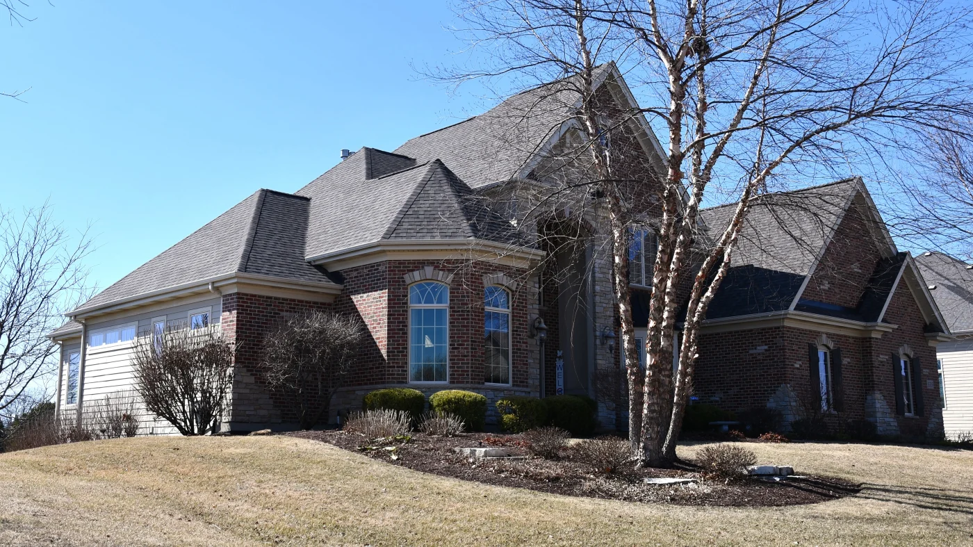 A view from the street of a house with a gray roof in Plainfield, IL, by Apex Exteriors, Inc.
