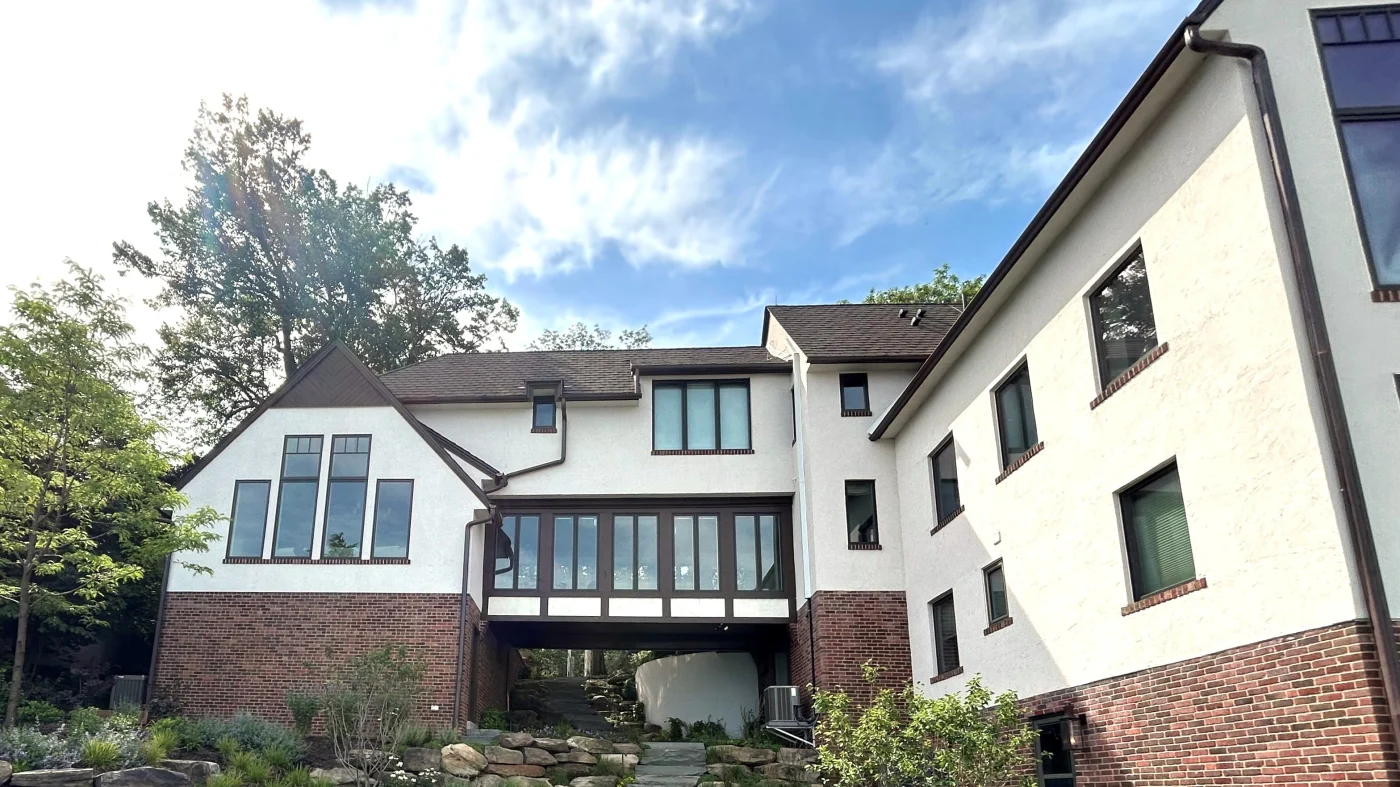 Professional Gutter Experts | Plainfield, IL | Apex Exteriors, Inc. The side of a building with multiple windows and two types of siding in Plainfield, IL, by Apex Exteriors, Inc.