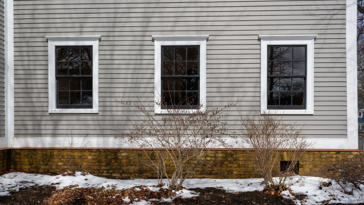 The side of a house with three windows trimmed in white in Elk Grove Village, IL, by Apex Exteriors, Inc.