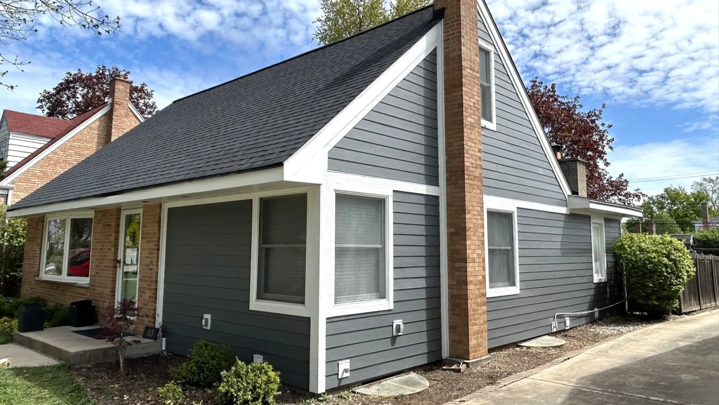 Remarkable Residential Siding | Plainfield, IL | Apex Exteriors, Inc. The side of a house with gray siding and white trim in Plainfield, IL, by Apex Exteriors, Inc.