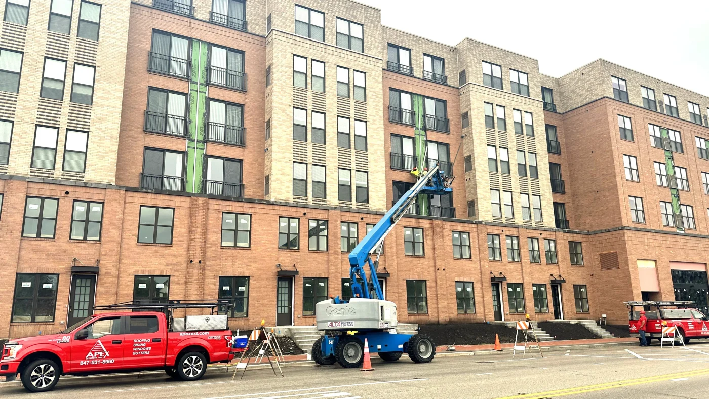 Multiple commercial buildings in a row with work equipment in front of them in Elk Grove Village, IL, by Apex Exteriors, Inc.