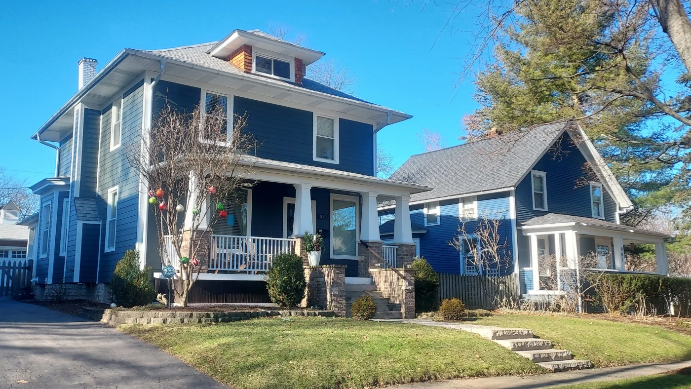 A view from a street of a large house with blue siding and white trim in Bloomingdale, IL, by Apex Exteriors, Inc.