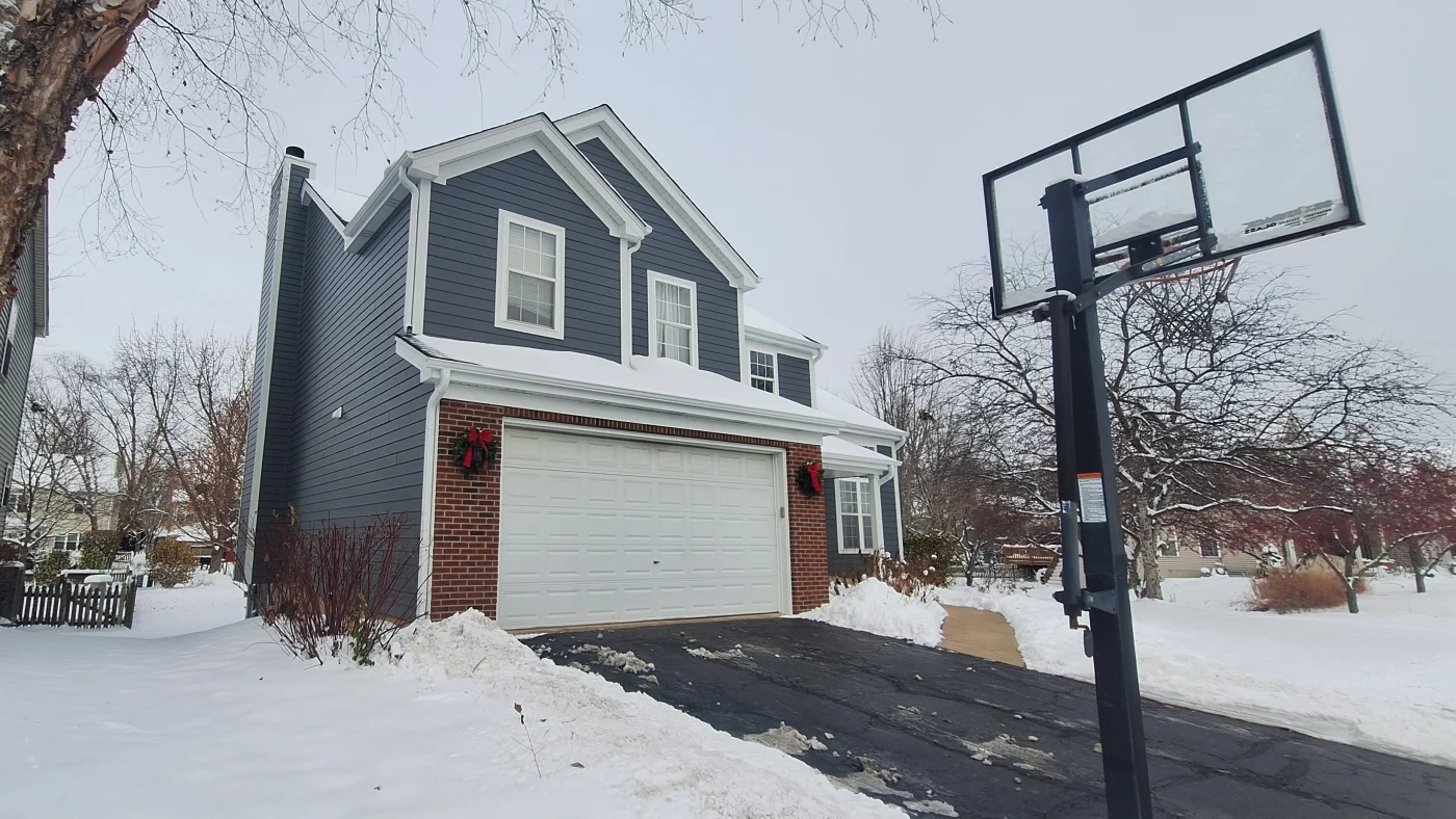 Dependable Siding Replacement Experts | Plainfield, IL | Apex Exteriors, Inc. The front of a house with gray siding and white trim in Plainfield, IL, by Apex Exteriors, Inc.