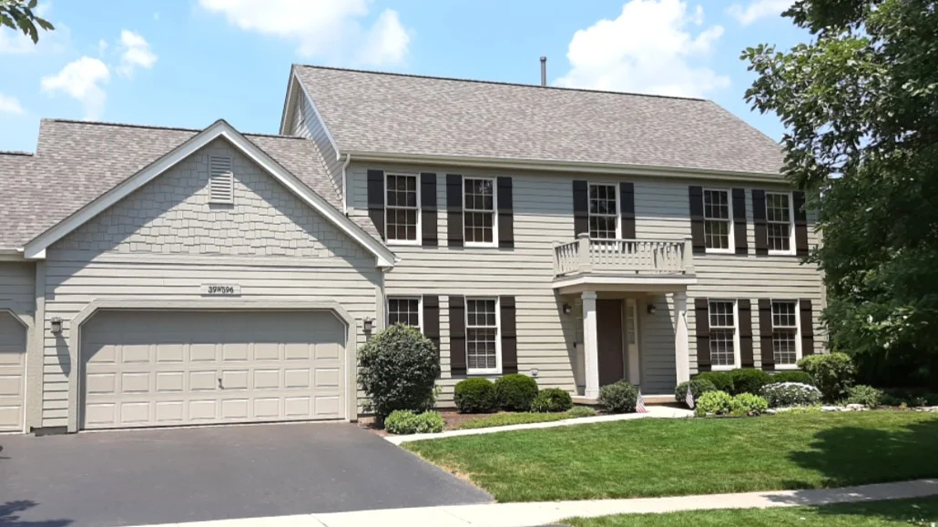 The front of a house with gray siding and a gray roof in Elk Grove Village, IL, by Apex Exteriors, Inc.