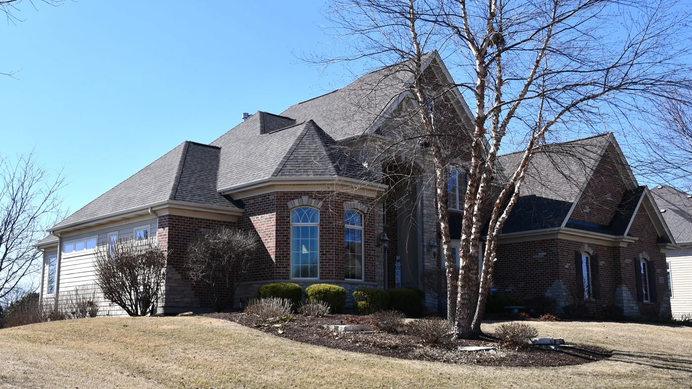 Exceptional Roofing Services | Naperville, IL | Apex Exteriors, Inc. The front of a house with a gray roof in Naperville, IL, by Apex Exteriors, Inc.
