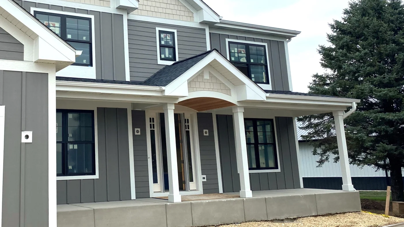 The front of a house with vertical gray siding and white trim in Elk Grove Village, IL, by Apex Exteriors, Inc.