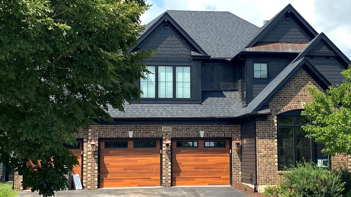 The front of a house with brown siding and a dark gray roof in Lombard, IL, by Apex Exteriors, Inc.