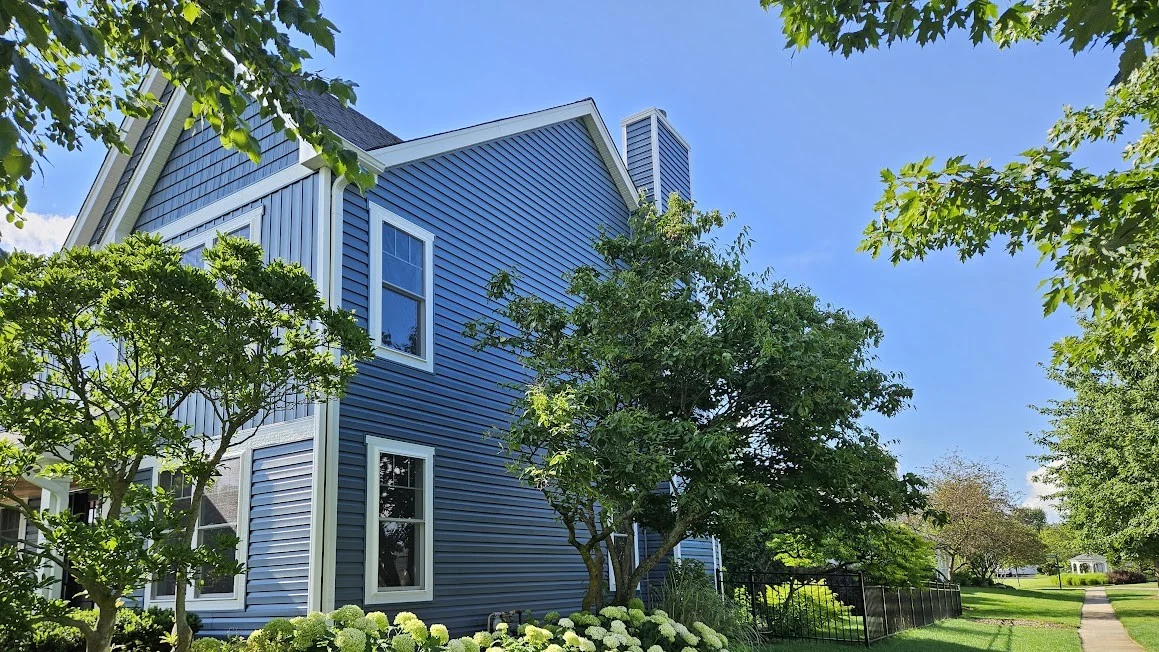 Outstanding Replacement Windows | Lombard, IL | Apex Exteriors, Inc. The side of a house with blue siding and white trim, in Lombard, IL, by Apex Exteriors, Inc.