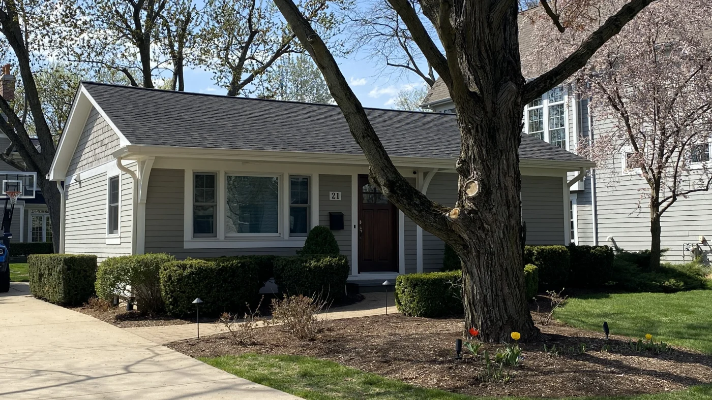The front of a house with light gray siding and a gray roof in Elmhurst, IL, by Apex Exteriors, Inc.
