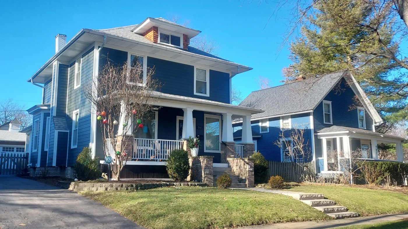 The front of a house from the street of a house with blue siding and white trim in Plainfield, IL, by Apex Exteriors, Inc.